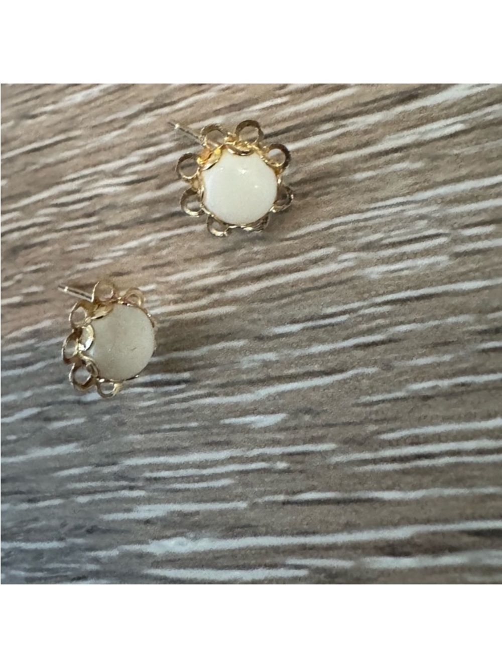 14k gold earrings with floral design and a white cabochon